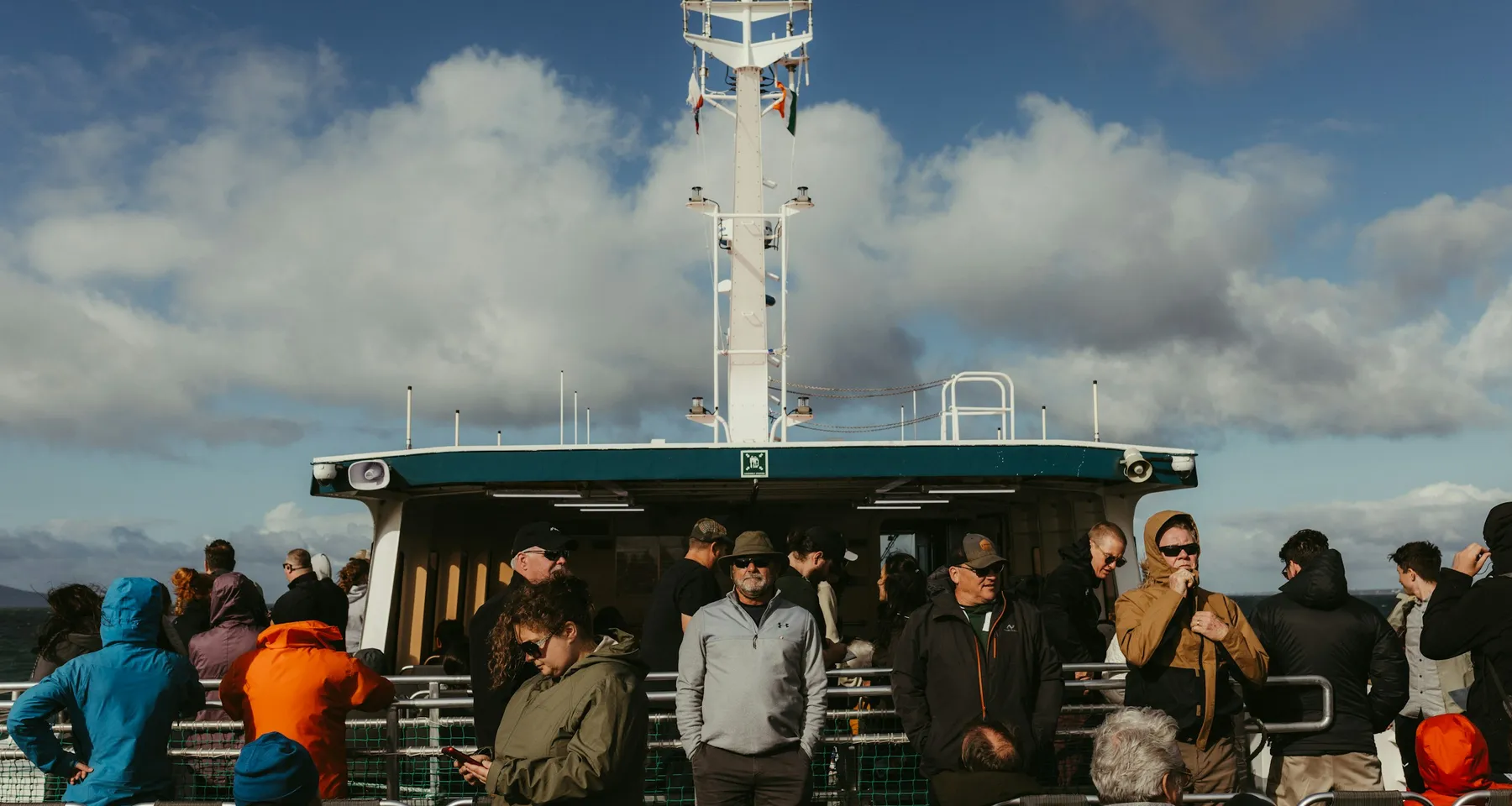 Passengers travelling together on the open deck of a ferry
